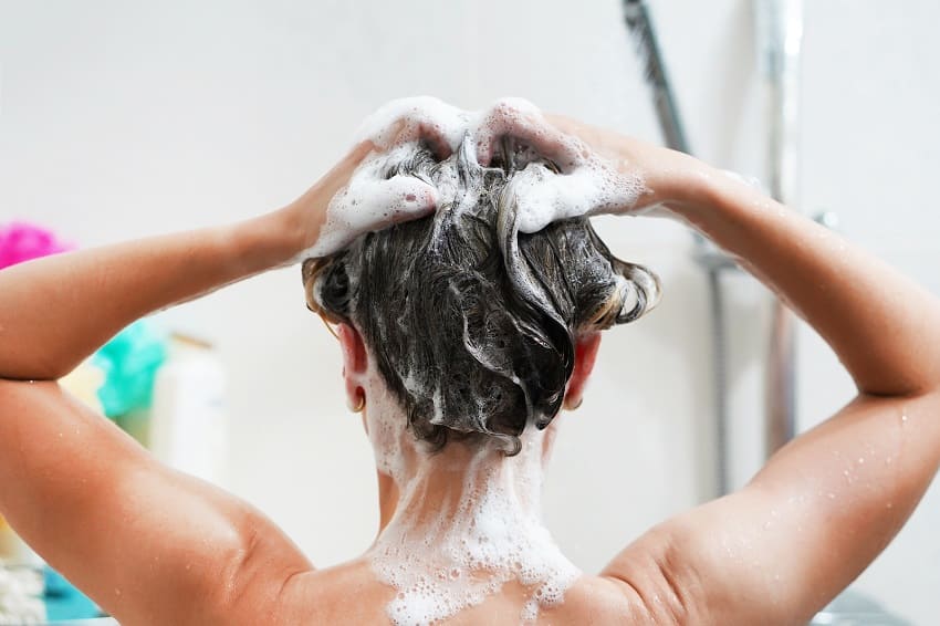 Person wäscht sich die Haare mit Shampoo