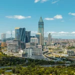 Panoramaaufnahme von Istanbul mit modernen Hochhäusern, Autobahnen und grünen Parkanlagen im Vordergrund